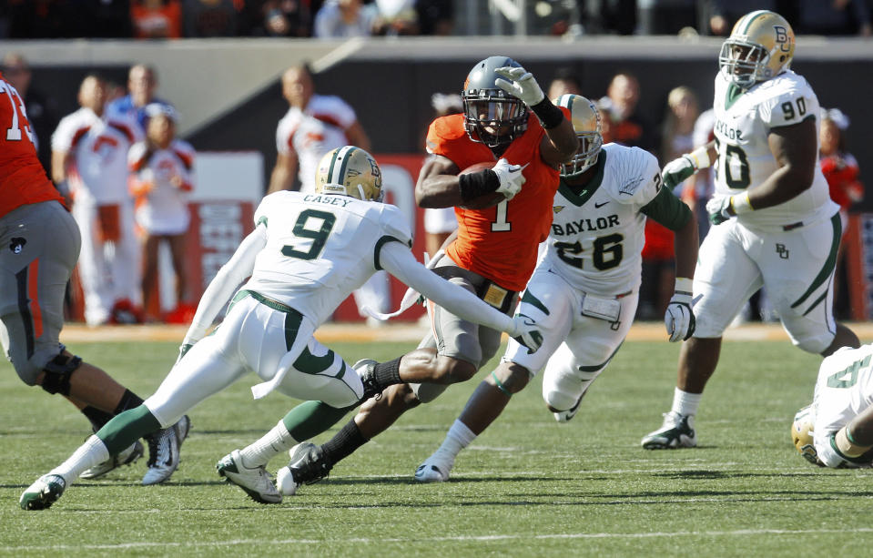 Oklahoma State running back Joseph Randle (1) carries the ball past Baylor's Chance Casey (9) during the first quarter of an NCAA college football game in Stillwater, Okla., Saturday, Oct. 29, 2011. Randle set career-highs by running for 152 yards and four touchdowns and Oklahoma State won 59-24. (AP Photo/Sue Ogrocki)