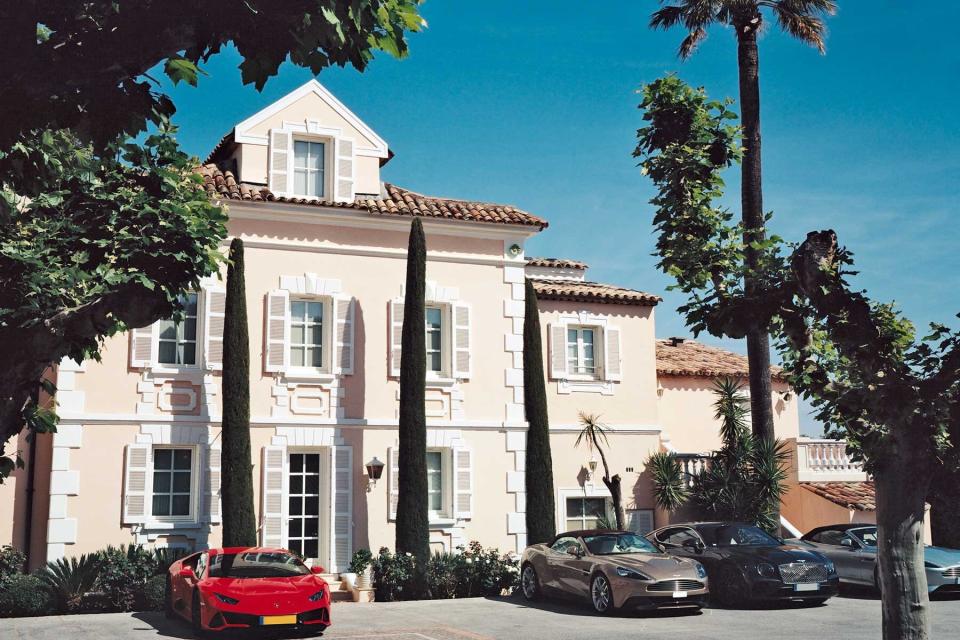 Sports cars outside of the pastel pink Cheval Blanc hotel in St Tropez