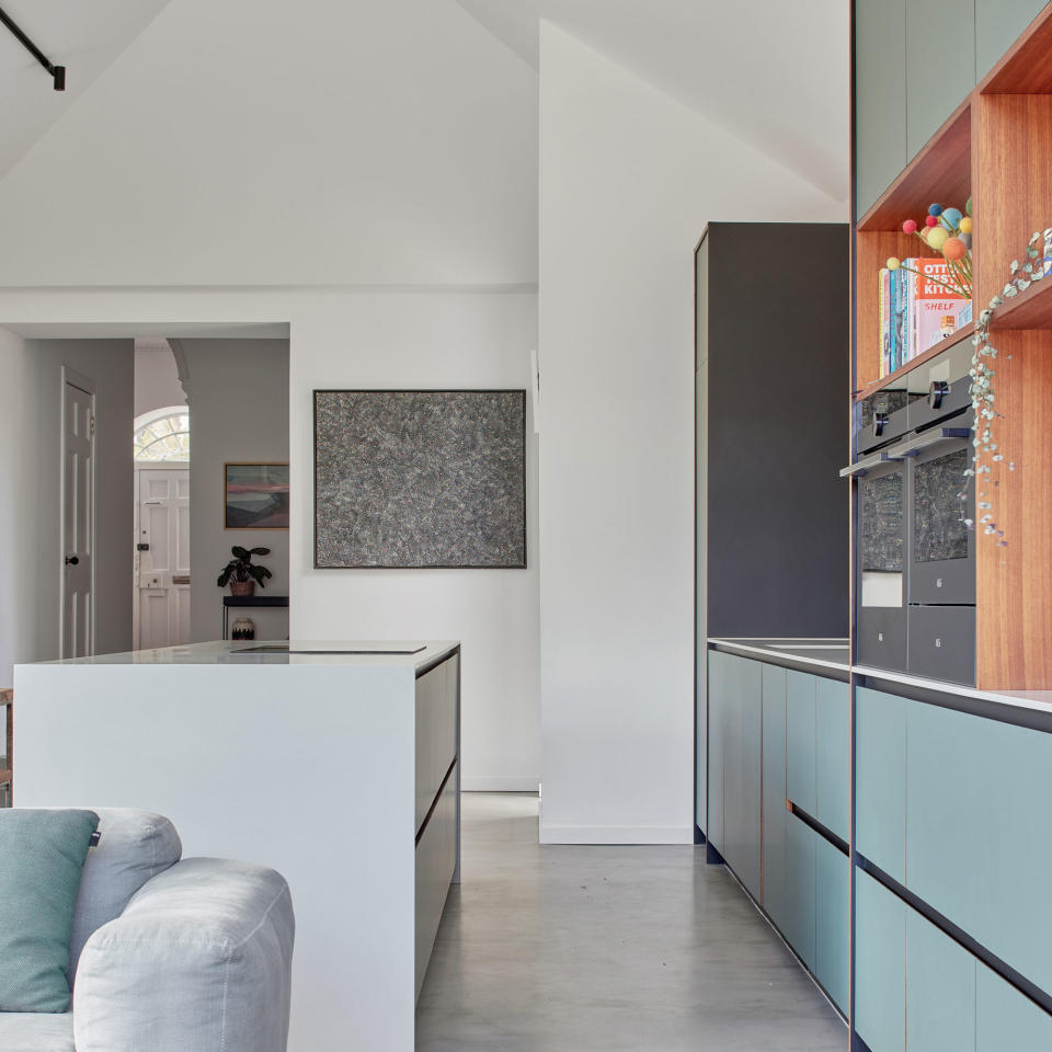 a pale blue plywood kitchen with white kitchen island