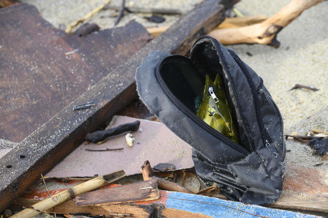 Personal belongings among the wreckage of a capsized boat washed ashore at a beach near Cutro, southern Italy, Monday, Feb. 27, 2023. Nearly 70 people died in last week's shipwreck on Italy's Calabrian coast. The tragedy highlighted a lesser-known migration route from Turkey to Italy for which smugglers charge around 8,000 euros per person. (AP Photo/Valeria Ferraro, File)