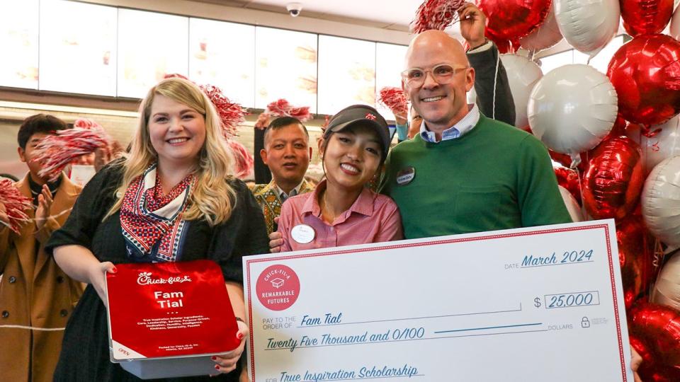 Chick-fil-A CEO Andrew Cathy, right, personally presented WT graduate student Fam Tial, center, with a $25,000 True Inspiration Scholarship on March 1, one of 14 awarded in North America. Also pictured is Carrie Gregory of Chick-fil-A, holding an oversized sauce packet containing a new MacBook.