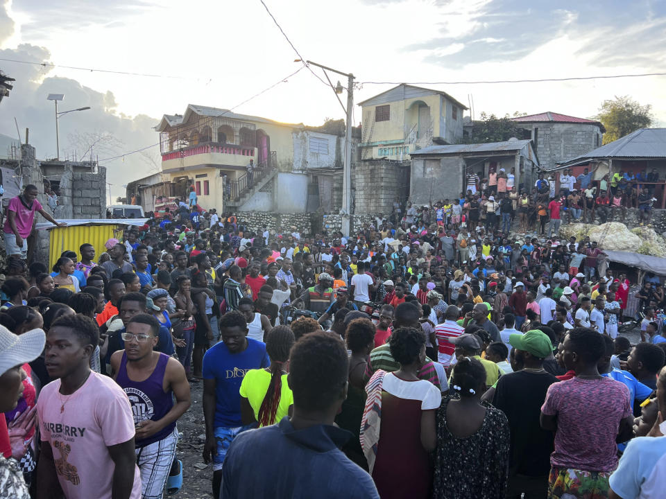 Una multitud observa las labores de rescate en viviendas que colapsaron luego de un sismo en Jeremie, Haití, el martes 6 de junio de 2023. (AP Foto/Ralph Simon)