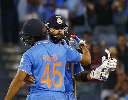 India's batsmen Rohit Sharma (L) and Virat Kohli embrace after defeating United Arab Emirates at their Cricket World Cup match in Perth, February 28, 2015. REUTERS/David Gray