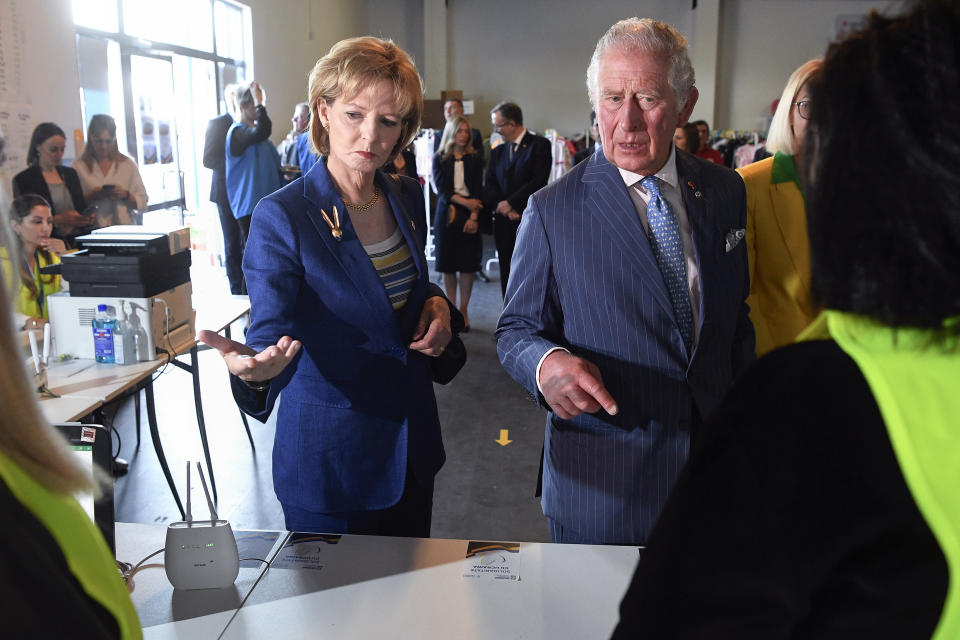 Britain's Prince Charles and Princess Margaret, the Custodian of the Romanian Crown, speak to staff members during a visit at a center for refugees fleeing the war in neighboring Ukraine, at the Romexpo convention center, in Bucharest, Romania, Wednesday, May 25, 2022. (Alex Micsik/Pool via AP)