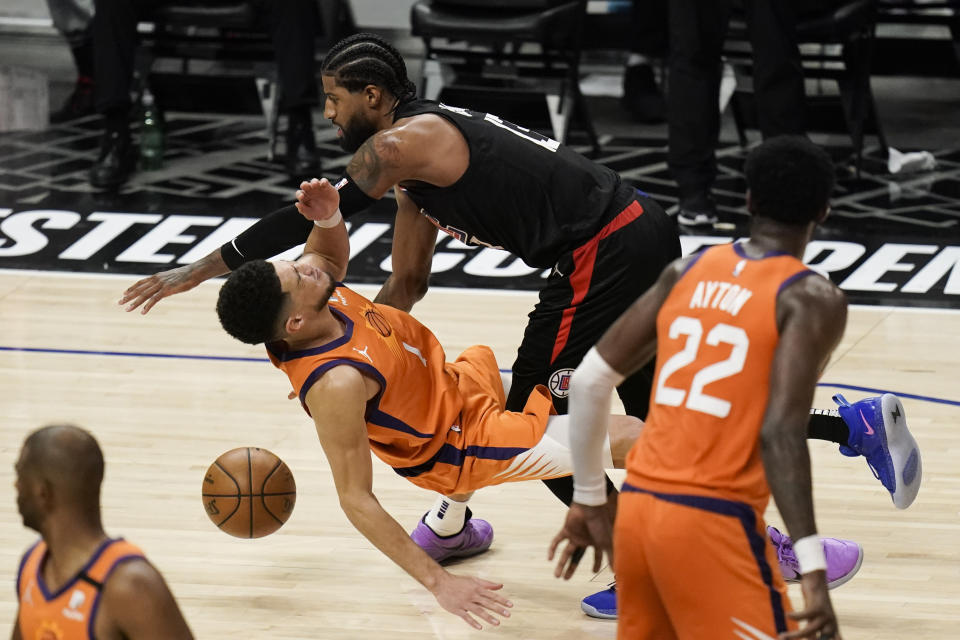 Los Angeles Clippers guard Paul George, top, fouls Phoenix Suns' Devin Booker during the second half in Game 6 of the NBA basketball Western Conference Finals Wednesday, June 30, 2021, in Los Angeles. (AP Photo/Jae C. Hong)