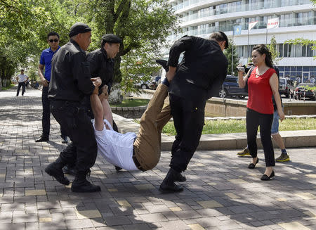 Police officers detain an opposition supporter attempting to stage a protest rally in Almaty, Kazakhstan June 23, 2018. REUTERS/Mariya Gordeyeva