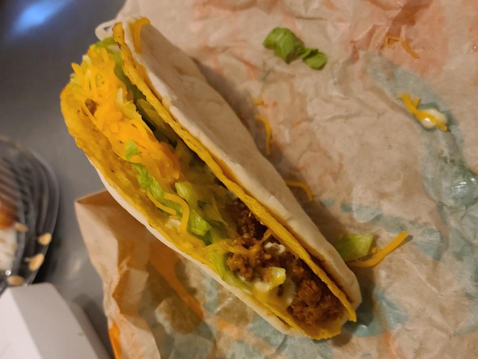 cheesy gordita crunch from taco bell resting on its wrapper