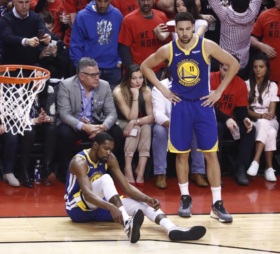 Golden State Warriors forward Kevin Durant #35 holds on to his calf after injuring it in a play against Toronto Raptors Serge Ibaka #9 as Golden State Warriors guard Klay Thompson #11 looks on during the first half of the NBA Finals basketball Game 5 between the Golden State Warriors and the Toronto Raptors. (Photo byEPA/LARRY W. SMITH)