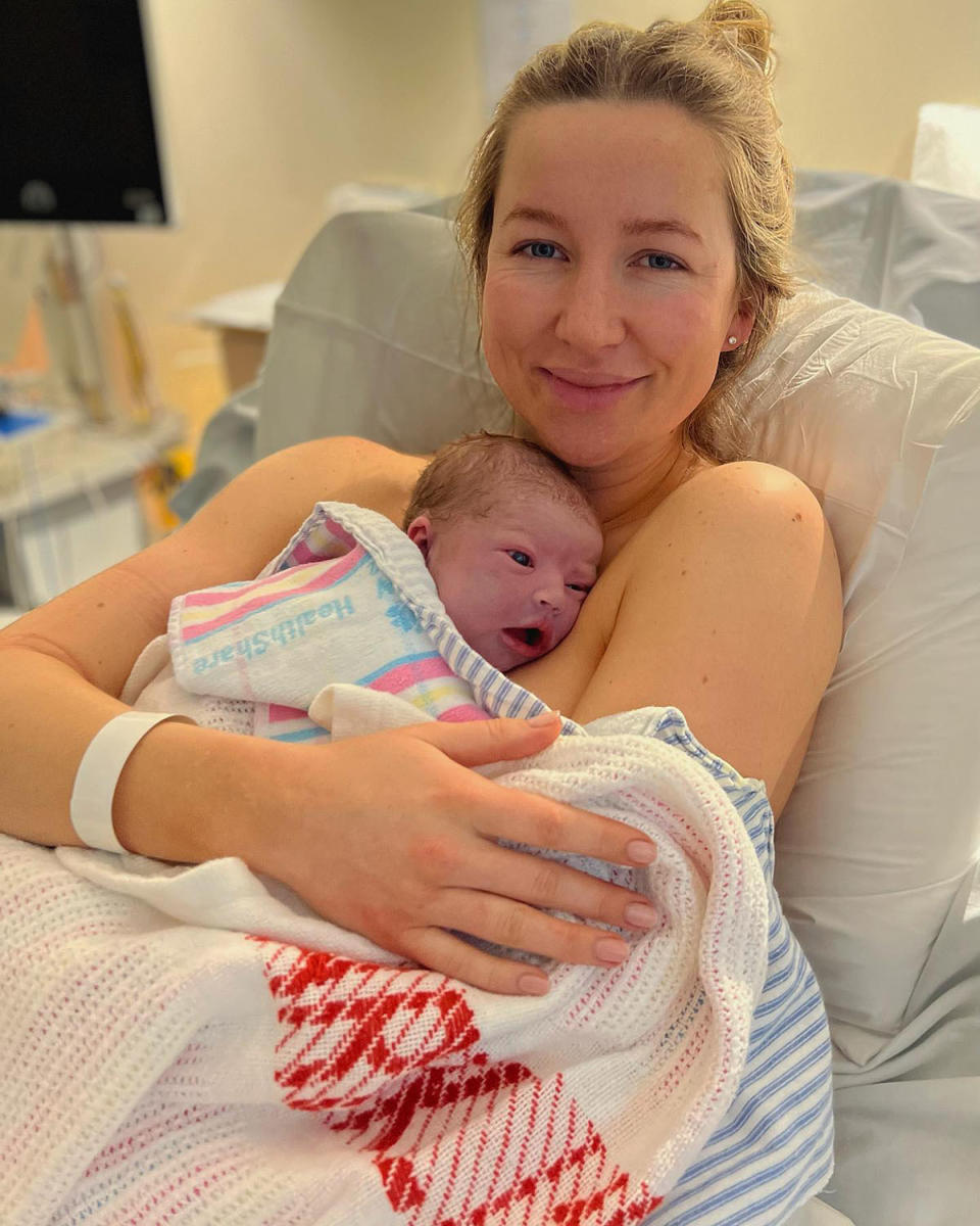 Rebecca James cuddling her newborn daughter Margot in hospital just after giving birth