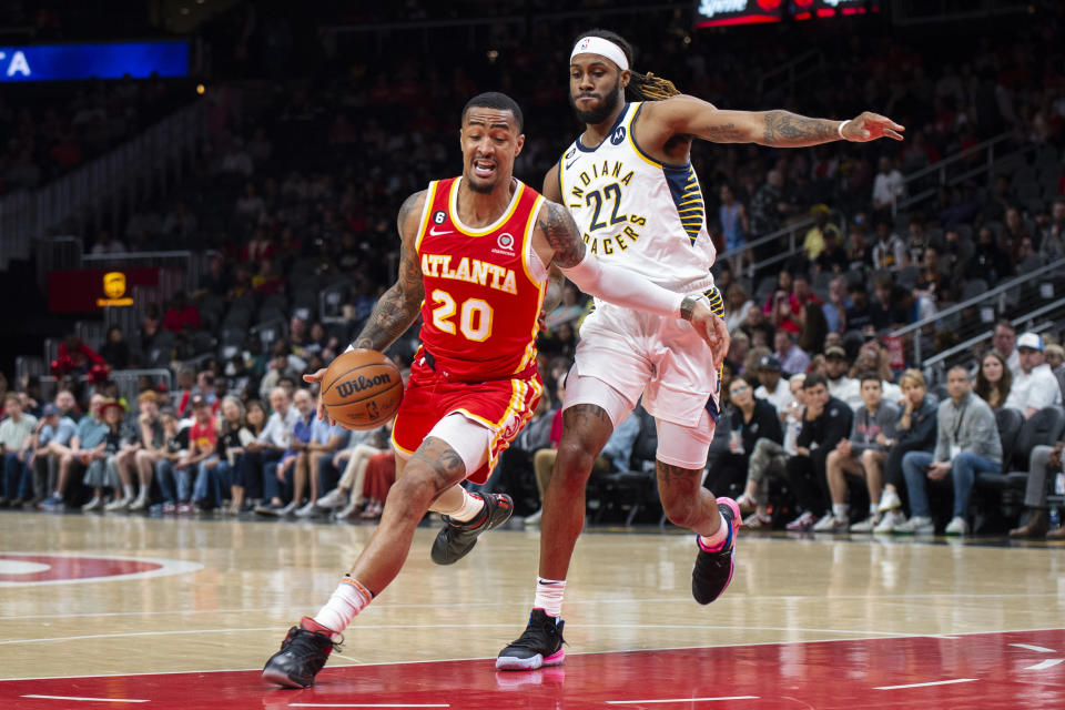 Atlanta Hawks forward John Collins dribbles past Indiana Pacers forward Isaiah Jackson during the first half of an NBA basketball game, Saturday, March 25, 2023, in Atlanta. (AP Photo/Hakim Wright Sr.)