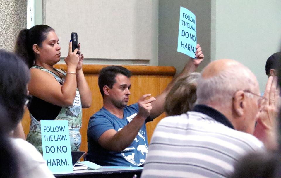 Water quality activist Michelle Coulson, also known as "Mermaid Michi" (left) and Sierra Club Florida Lead Organizer Michael McGrath (right), listen intently to public comment at a Florida Department of Environmental Protection meeting at the Alachua County Headquarters Library on Monday, Aug. 28, 2023.