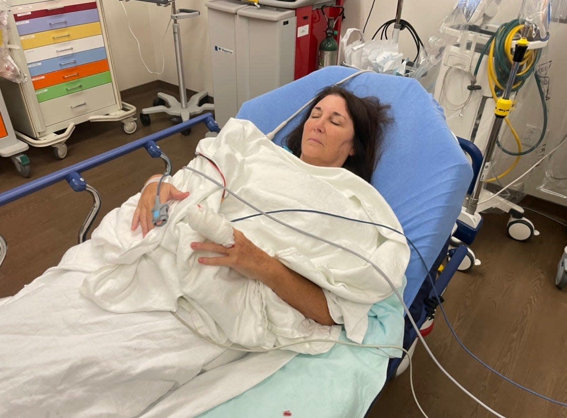 Bobbie Haverly in the hospital receiving treatment for a severed finger after a library book return box door tore it off.