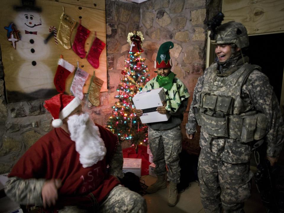 A US soldier from the 101st Airborne dressed as Santa Claus hands out gifts at a combat outpost at the Sabari District Center on Christmas Day December 25, 2008 in Sabari District, Khost Province, Afghanistan.