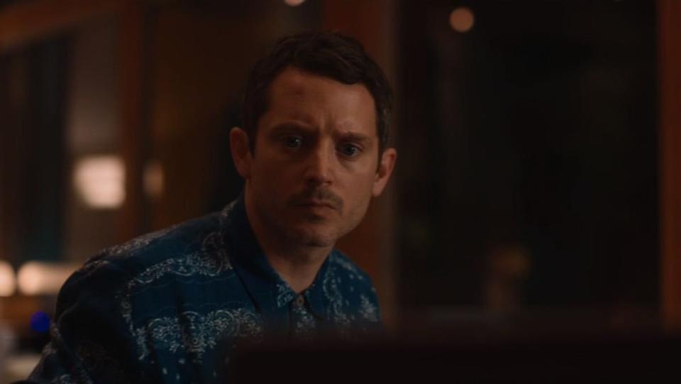 Elijah Wood as Walter Tattersall looks at a computer screen in disbelief on Yellowjackets