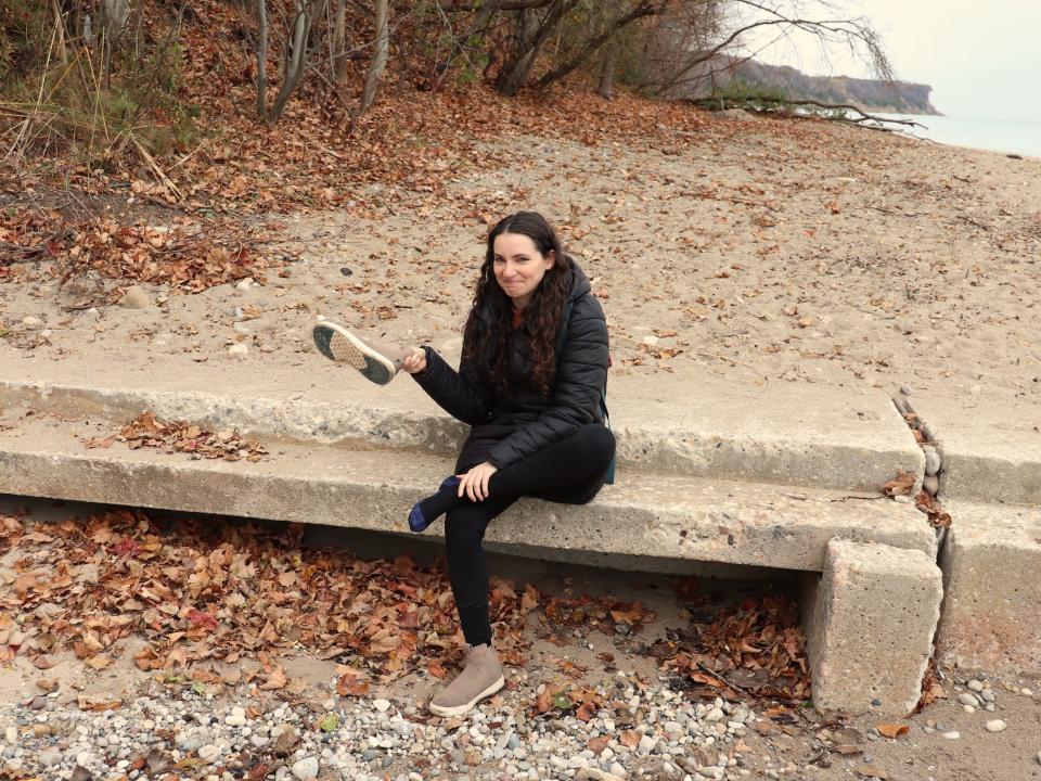 Talia Lakritz dumps water out of her shoe on the beach on Lake Michigan