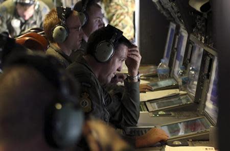 A crew member aboard a Royal New Zealand Air Force (RNZAF) P3 Orion maritime search aircraft reacts as he looks at screens while flying over the southern Indian Ocean looking for missing Malaysian Airlines flight MH370 April 4, 2014. REUTERS/Nick Perry/Pool