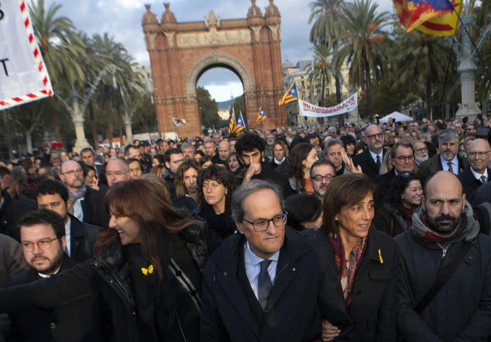 Catalan regional president Quim Torra, centre, walks to the Catalonia's high court in Barcelona, Spain, Monday, Nov.18, 2019. The pro-independence regional president of Catalonia is standing trial for allegedly disobeying Spain's electoral board by not removing pro-secession symbols from public buildings during an election campaign. (AP Photo/Joan Mateu)