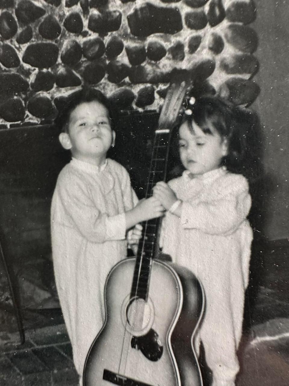 Kym Gouchie as a young girl with a guitar, and her brother, Buddy Gouchie.
