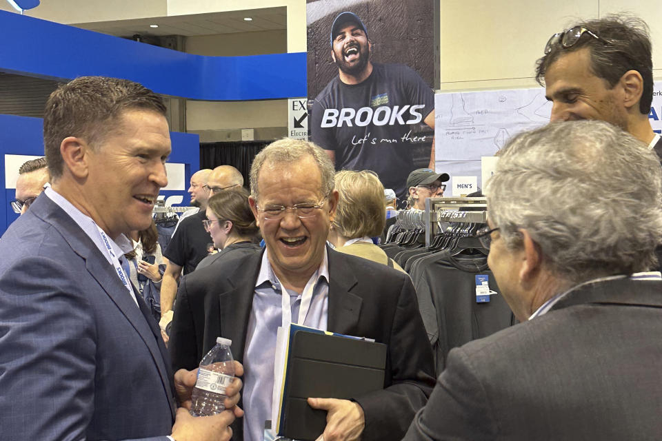 Berkshire Hathaway investment manager Ted Weschler, center, talks with Brooks Running CEO Dan Sheridan, Friday, May 3, 2024, in Omaha, Neb., a day ahead of the annual shareholder meeting.  (AP Photo/Josh Funk)