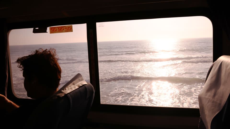 A passenger rides an Amtrak train passing near the Pacific Ocean on November 9, 2021 near Oceanside, California. - Mario Tama/Getty Images