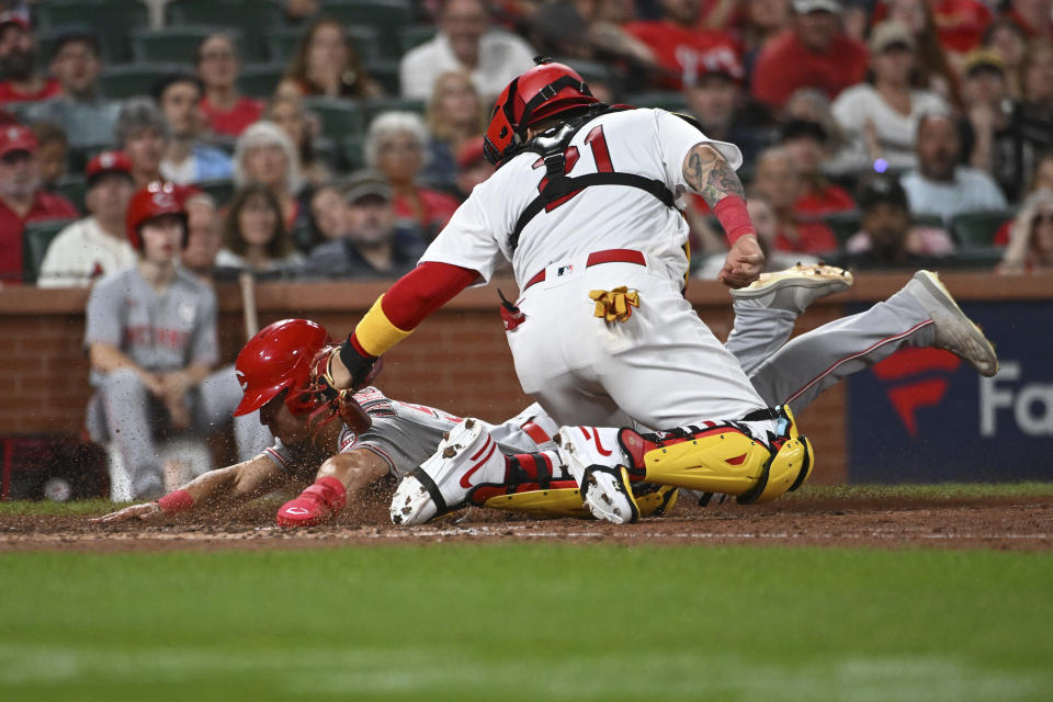 Cincinnati Reds' Stuart Fairchild, left, is tagged out at home plate by St. Louis Cardinals catcher Yadier Molina during the eighth inning of a baseball game Thursday, Sept. 15, 2022, in St. Louis. (AP Photo/Joe Puetz)