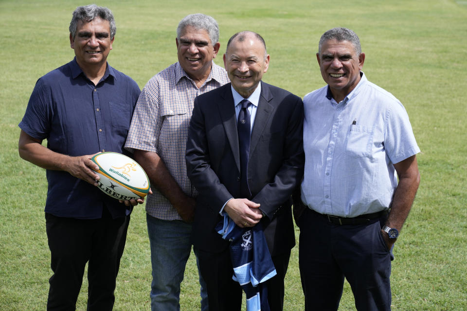 Australia's head rugby union coach Eddie Jones, second right, poses with Gary Ella, left, Glen Ella and Mark Ella, right, at Matraville Sports High School in Sydney, Tuesday, Jan. 31, 2023. Jones, who was named as new coach of the Australian rugby team on Jan. 16, faced the media on Tuesday in his first appearance since returning to the Wallabies. He will lead the team at the Rugby World Cup later this year in France. (AP Photo/Rick Rycroft)