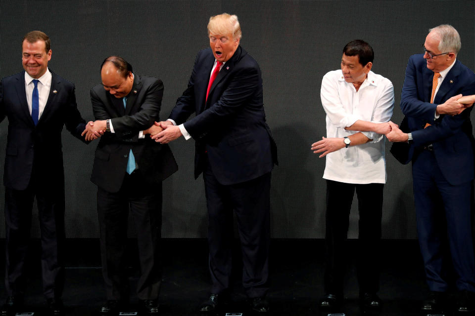 Trump registers his surprise as he&nbsp;realizes other leaders, including Russia's Prime Minister Dmitry Medvedev, Vietnam's Prime Minister Nguyen Xuan Phuc, President of the Philippines Rodrigo Duterte and Australia's Prime Minister Malcolm Turnbull, are crossing their arms for the traditional "ASEAN handshake" as he participates in the opening ceremony of the ASEAN Summit in Manila, Philippines,&nbsp;on Nov. 13.