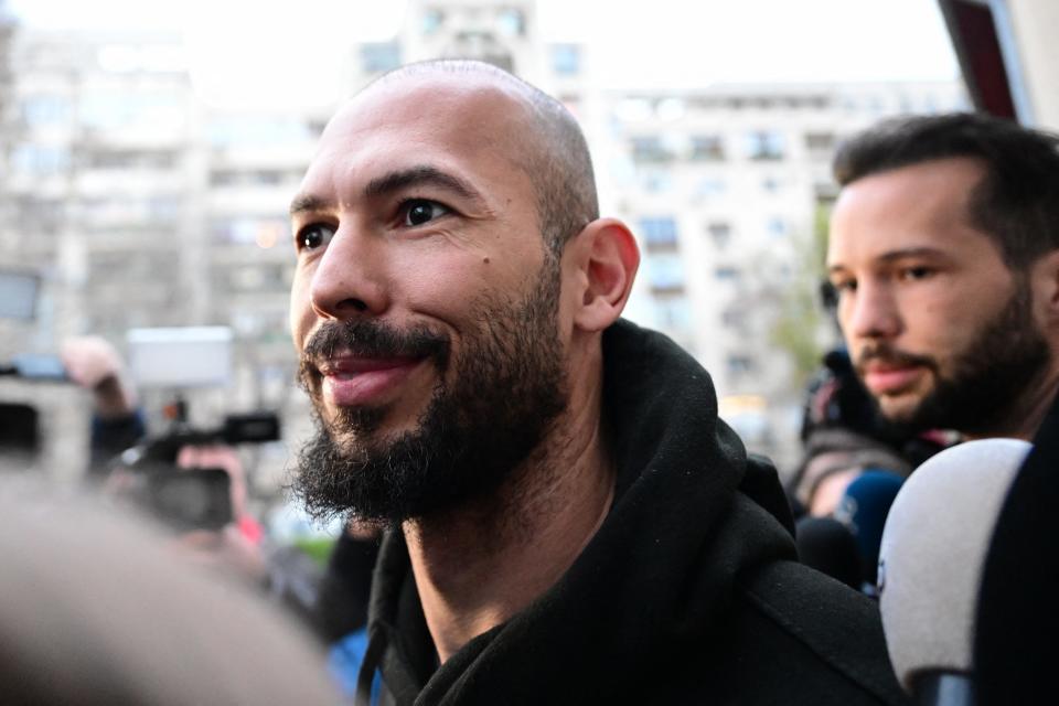 British-US former professional kickboxer and controversial influencer Andrew Tate (L) and his brother Tristan Tate (R) leave after having been released from detention in Bucharest, Romania on March 12, 2024, after they appeared in a court after Romanian police detained them over UK sex offence charges. A Bucharest court on March 12 granted a request to extradite controversial influencer Andrew Tate to the UK over sex offence charges, but only after the conclusion of legal proceedings in Romania in a separate case. The Bucharest appeals court ruling "orders the execution of the warrant of arrest issued on 19 January 2024" by the Westminster Magistrates' Court, but postpones extradition "until the final resolution of the case" in Romania, which could take years. (Photo by Daniel MIHAILESCU / AFP) (Photo by DANIEL MIHAILESCU/AFP via Getty Images)