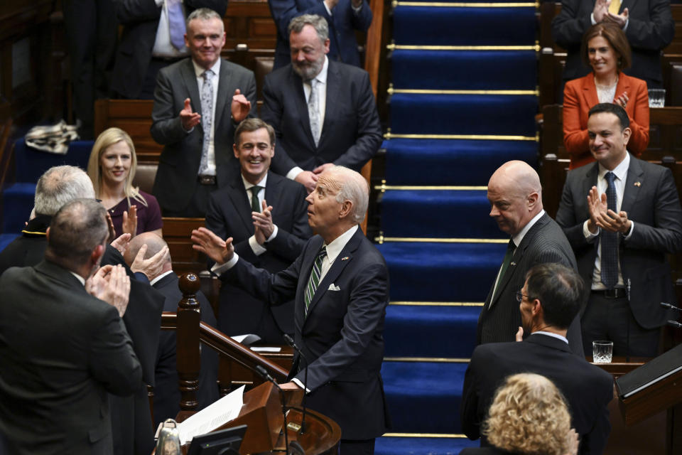 Members of parliament stand as President Joe Biden arrives to address members of the Irish parliament at Leinster House in Dublin, Thursday, April 13, 2023. Ireland's Taoiseach Leo Varadkar applauds at right. (Kenny Holston/The New York Times via AP, Pool)