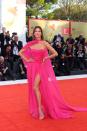 <p>The model opted for a hot pink chiffon gown and cape by Ermanno Scervino.</p>