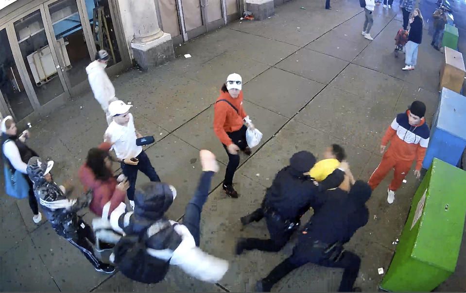 This image from video provided by the Office of the Manhattan District Attorney, Thursday, Feb. 8, 2024, shows the brawl between New York City Police Department officers and migrants in Times Square, Jan. 27, 2024. Manhattan D.A. Alvin Bragg announced six additional indictments of men allegedly involved in a brawl with police officers in Times Square, but he said investigators were still working to identify several suspects and their exact role in the frenzy. (Manhattan District Attorney via AP)