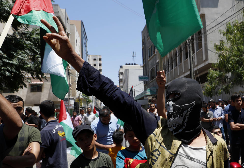 Hamas supporter covers his face while while chants slogans during a protest against Israel's plan to annex parts of the West Bank and U.S. President Donald Trump's mideast initiative, after Friday prayer at the main road of Khan Younis City, Gaza Strip, Friday, June 26, 2020. (AP Photo/Adel Hana)