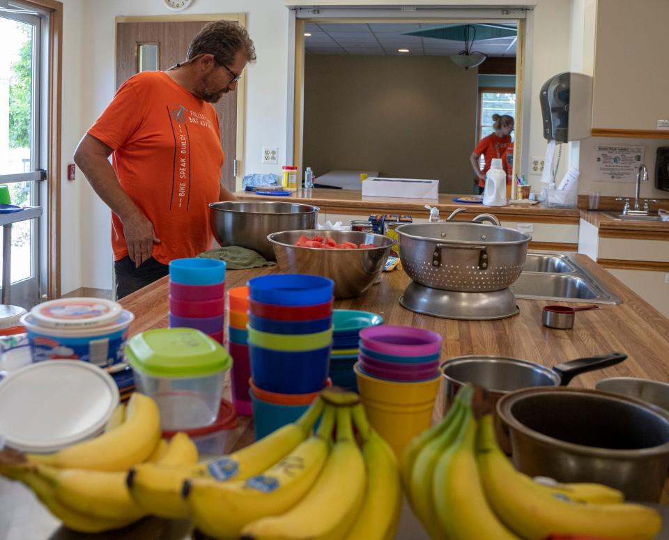 Rolff Christensen, 63, of California, part of the cyclist group of Fuller Center Bike Adventure handles dinner for the group at Milan Free Methodist Church during their rest stop in Milan on Tuesday, July 5, 2022.
