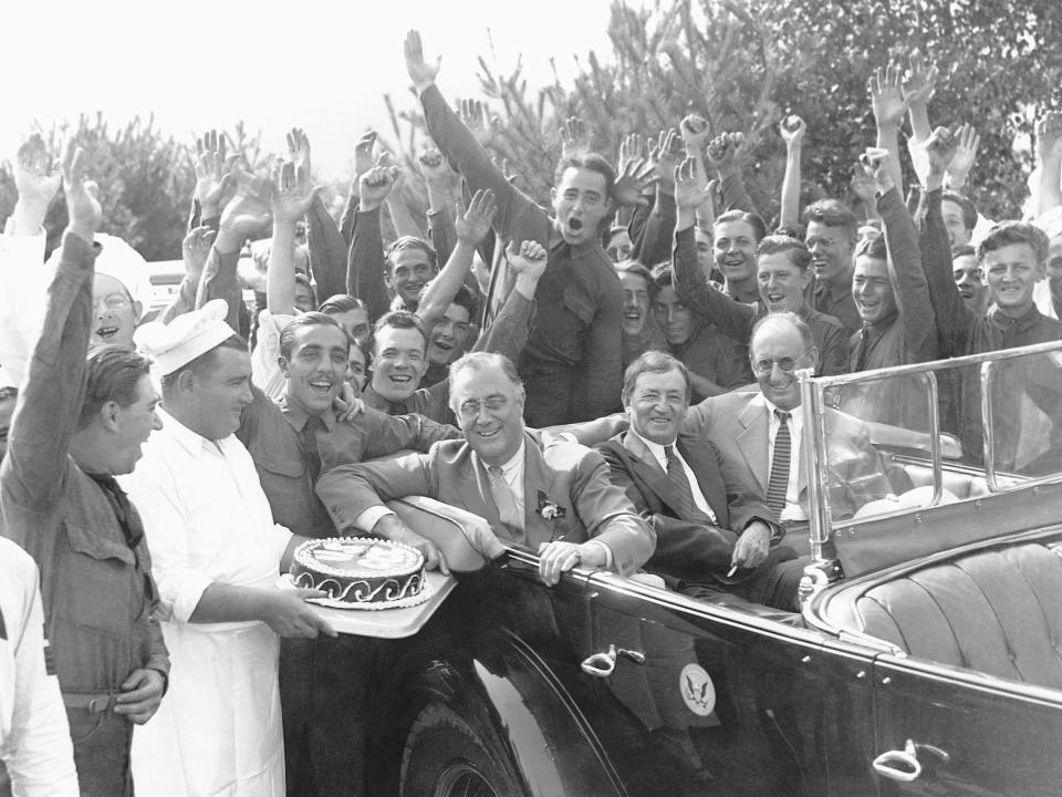 A photo of President Roosevelt in a car surrounded by men from the CCC