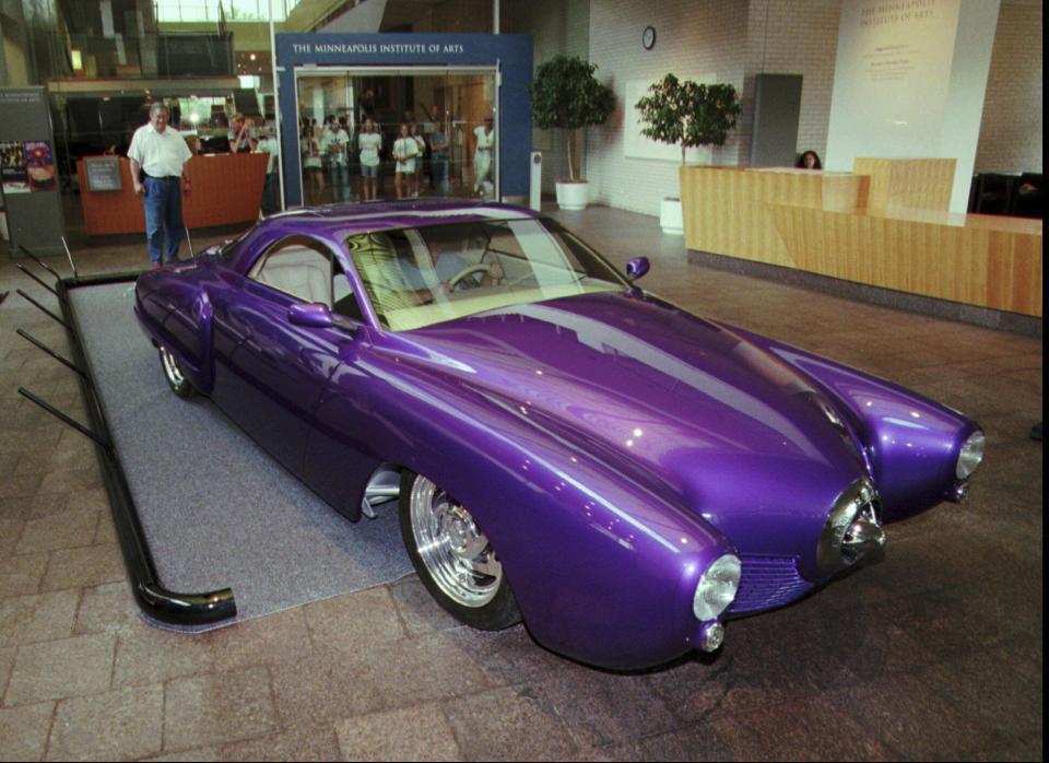 FILE - Greg Fleury stands by the purple automobile creation called Frankenstude in the lobby of the Minneapolis Institute of Arts Monday, July 21, 1997. Frankenstude is a 1990's interpretation of the 1940's-50's icon, the bullet-nosed Studebaker. (AP Photo/Jim Mone, File)