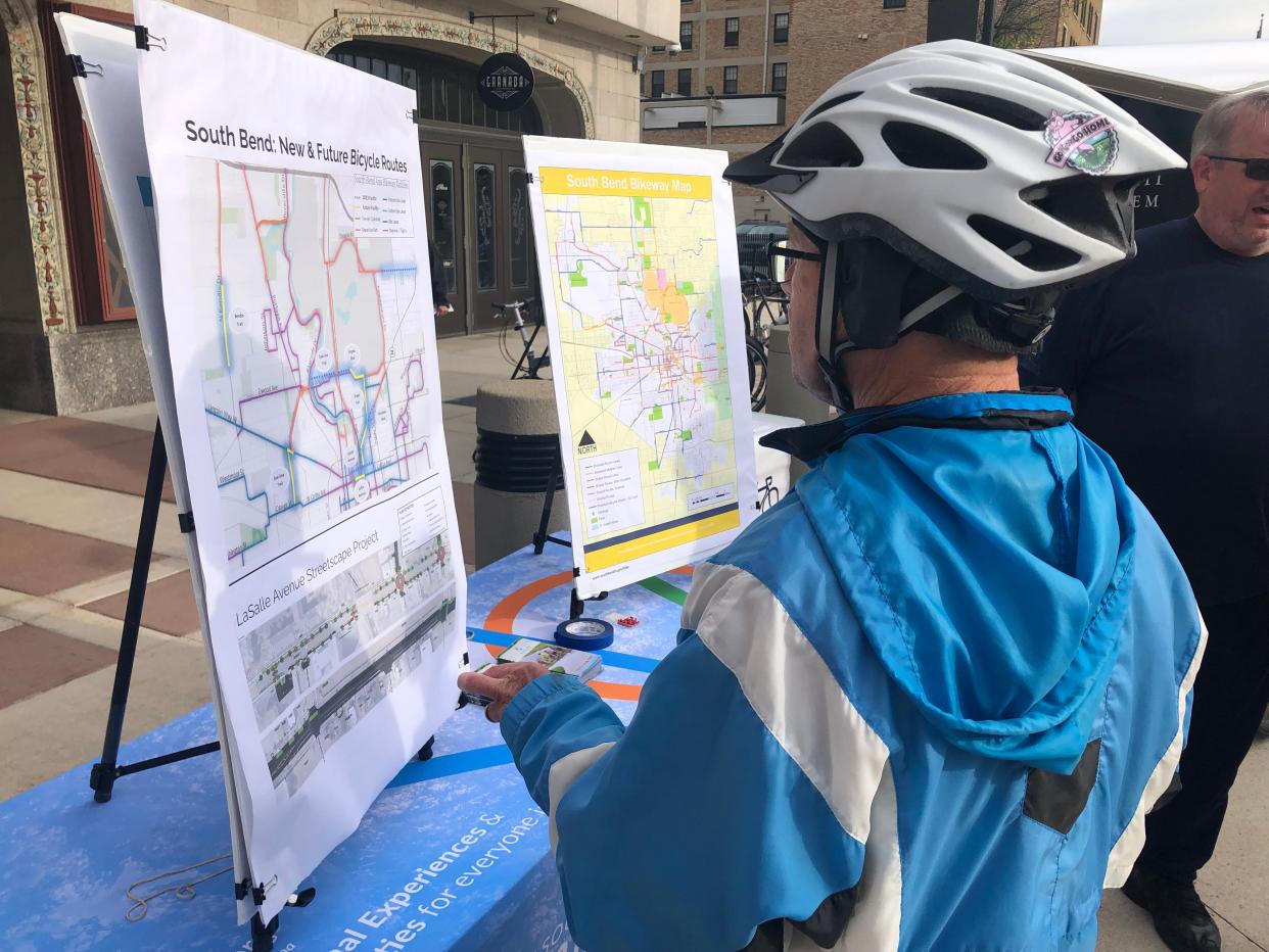 A cyclists examines maps of current and proposed bike routes at 2023's Michiana Bike to Work Week pancake breakfast at the Jon Hunt Memorial Plaza in South Bend.