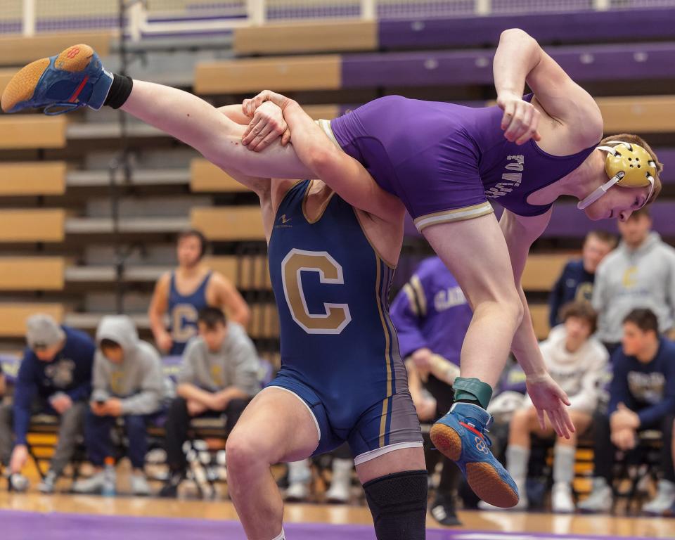 Fowlerville's Vincent Saunders goes airborne during a 165-pound match against Chelsea's Thomas Shemwell during the district final on Wednesday, Feb. 8, 2023.