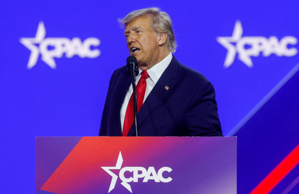 Former President Donald Trump stands at a podium, the front of which is labeled: CPAC.