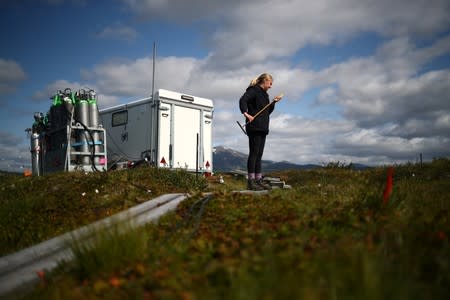 Kathryn Bennett, a postgraduate student in earth science at the University of New Hampshire, inspects an avalanche pole at an Arctic research post at Stordalen Mire near Abisko