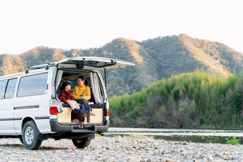 Young girl and her mother relaxing in a camper van