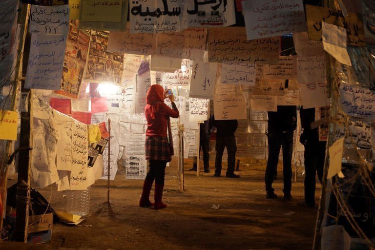 An Egyptian woman visits an installation made of political art and slogans in Cairo's Tahrir Square. President Mohamed Morsi backed down in a political crisis marked by weeks of street protests, after the powerful army gave an ultimatum to him and the opposition to hold talks. But the initial signs were that his concession would not satisfy an increasingly fierce opposition