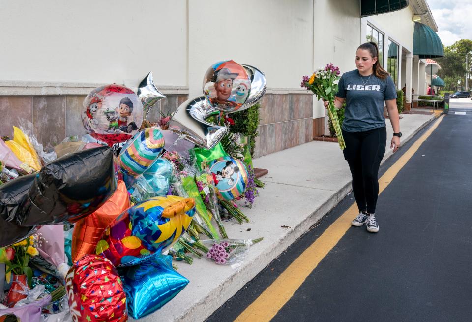 Katie Howey brings flowers to a memorial in front of a Publix Super Market in Royal Palm Beach, Florida on June 13, 2021. Timothy Wall shot and killed a 69-year-old grandmother and her toddler grandson inside the store before killing himself on Thursday. Greg Lovett/The Palm Beach Post