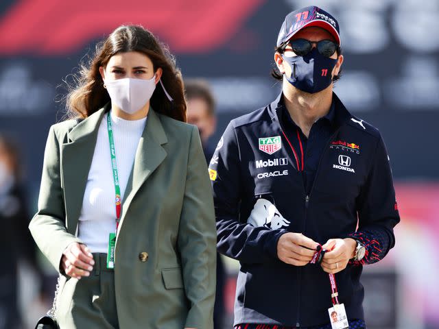 <p>Peter Fox/Getty</p> Sergio Perez walks in the Paddock with Carola Martinez ahead of final practice for the F1 Grand Prix of Portugal on May 01, 2021.