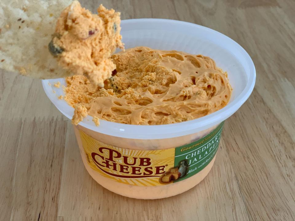 chip dipping into trader joe's jalepeno pub cheese dip