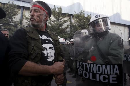 A Greek farmer stands next to a riot police officer during a demonstration against planned pension reforms in the northern city of Thessaloniki, Greece, January 28, 2016. REUTERS/Alexandros Avramidis