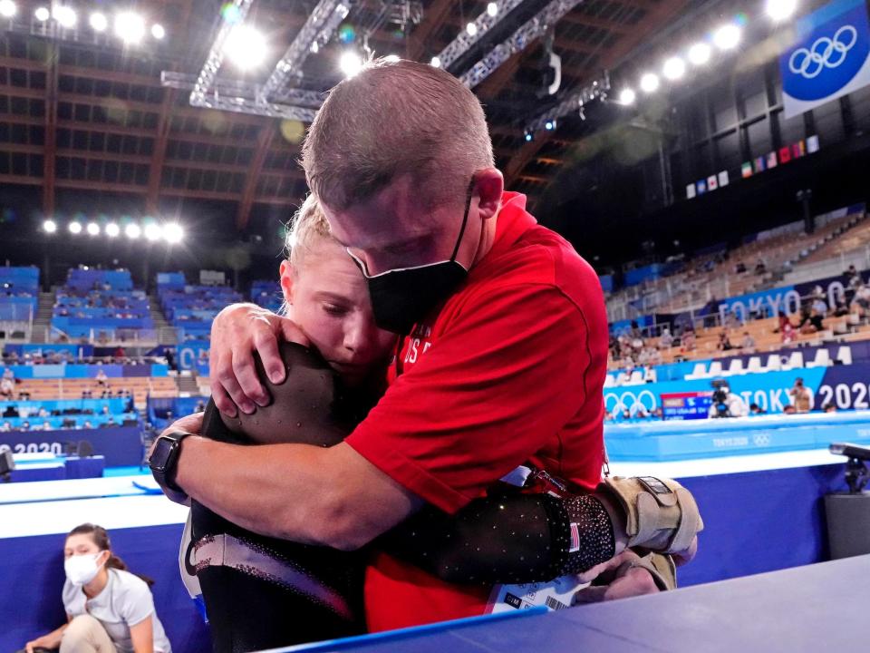 Brian Carey (right) - Jade Carey's father and coach - comforts his daughter after her vault mishap.