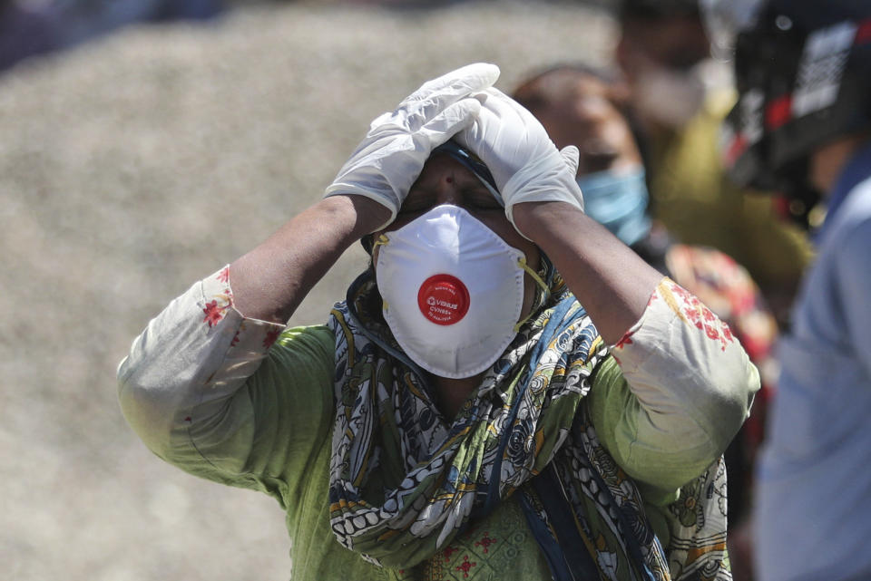 FILE - In this April. 25, 2021, file photo, a relative of a person who died of COVID-19 reacts at a crematorium in Jammu, India. Despite clear signs that India was being swamped by another surge of coronavirus infections, Prime Minister Narendra Modi refused to cancel campaign rallies, a major Hindu festival and cricket matches with spectators. The crisis has badly dented Modi’s carefully cultivated image as an able technocrat. (AP Photo/Channi Anand, File)