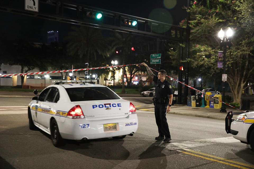 <p>A Jacksonville Sheriff’s officer helps keep the perimeter secure as law enforcement investigates a shooting at the GLHF Game Bar which uses the same entrance as the Chicago Pizza place (seen in the center to the rear) at the Jacksonville Landing on Aug. 27, 2018 in Jacksonville, Fla. (Photo: Joe Raedle/Getty Images) </p>