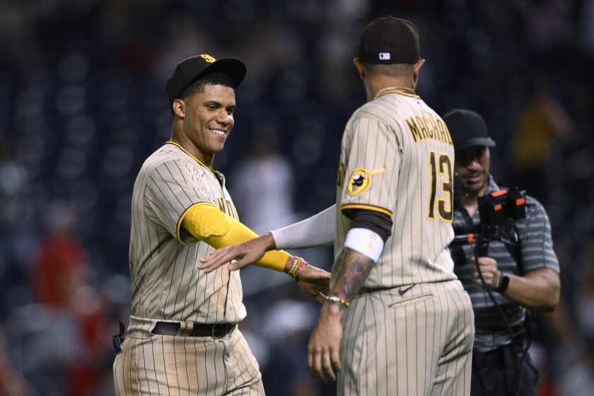 El dominicano Juan Soto festeja con su compañero y compatriota dominicano Manny Machado tras la victoria de los Padres de San Diego sobre los Nacionales de Washington, el viernes 12 de agosto de 2022 (AP Foto/Nick Wass)