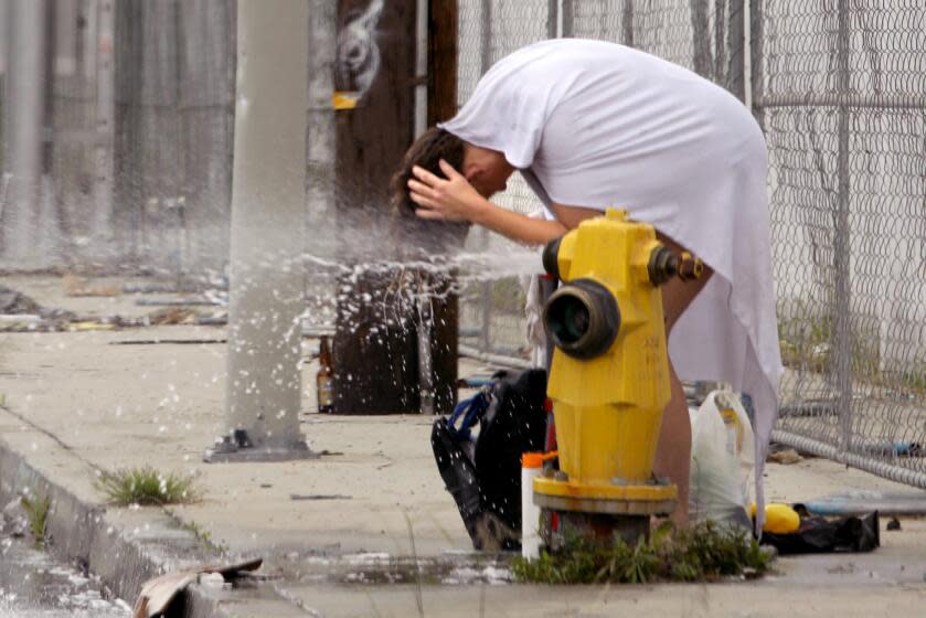 LOS ANGELES, CA - FEBRUARY 27, 2024 - - A homeless woman washes up at a fire hydrant near her encampment, off camera, along S. Lemon Street in downtown Los Angeles on February 27, 2024. The 2023 Greater Los Angeles Homeless Count revealed a 9% year-over-year increase in homelessness in Los Angeles County and a 10% rise in Los Angeles. The data showed 75,518 people experienced homelessness in Los Angeles County, and 46,260 in Los Angeles. (Genaro Molina/Los Angeles Times)